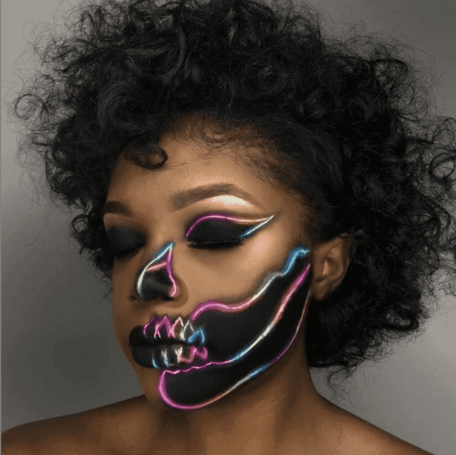 makeup artist with neon Halloween themed makeup