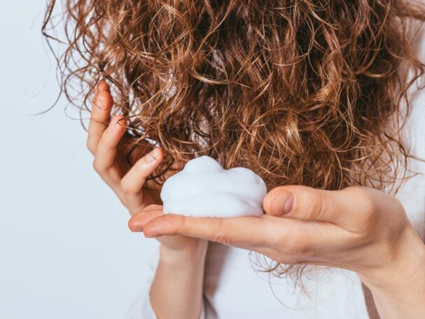 woman putting product on her hair